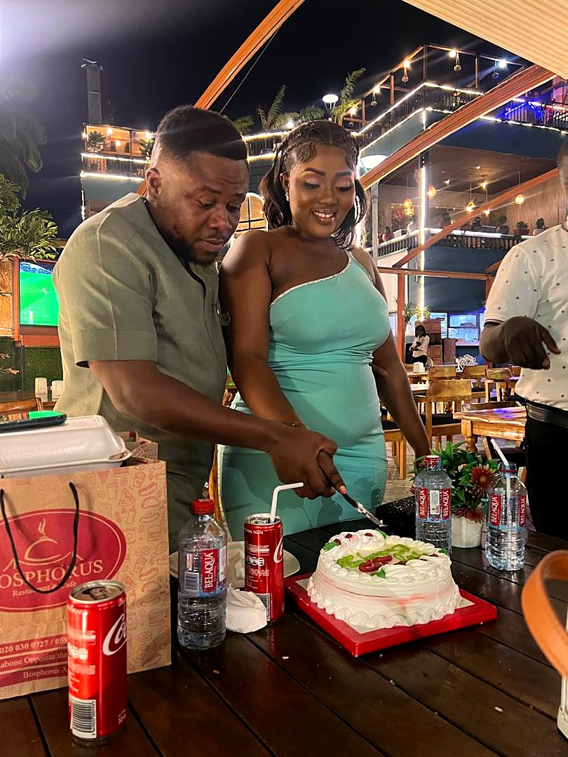 Eddy and Kessewa cutting a celebration cake together