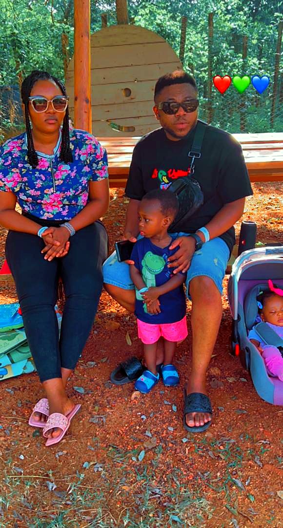 Eddy and Kessewa relaxing outdoors with their children
